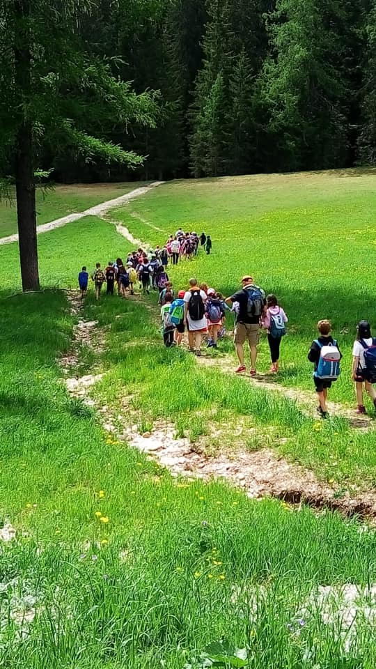 bambini passeggiano in fila in montagna a Corvara